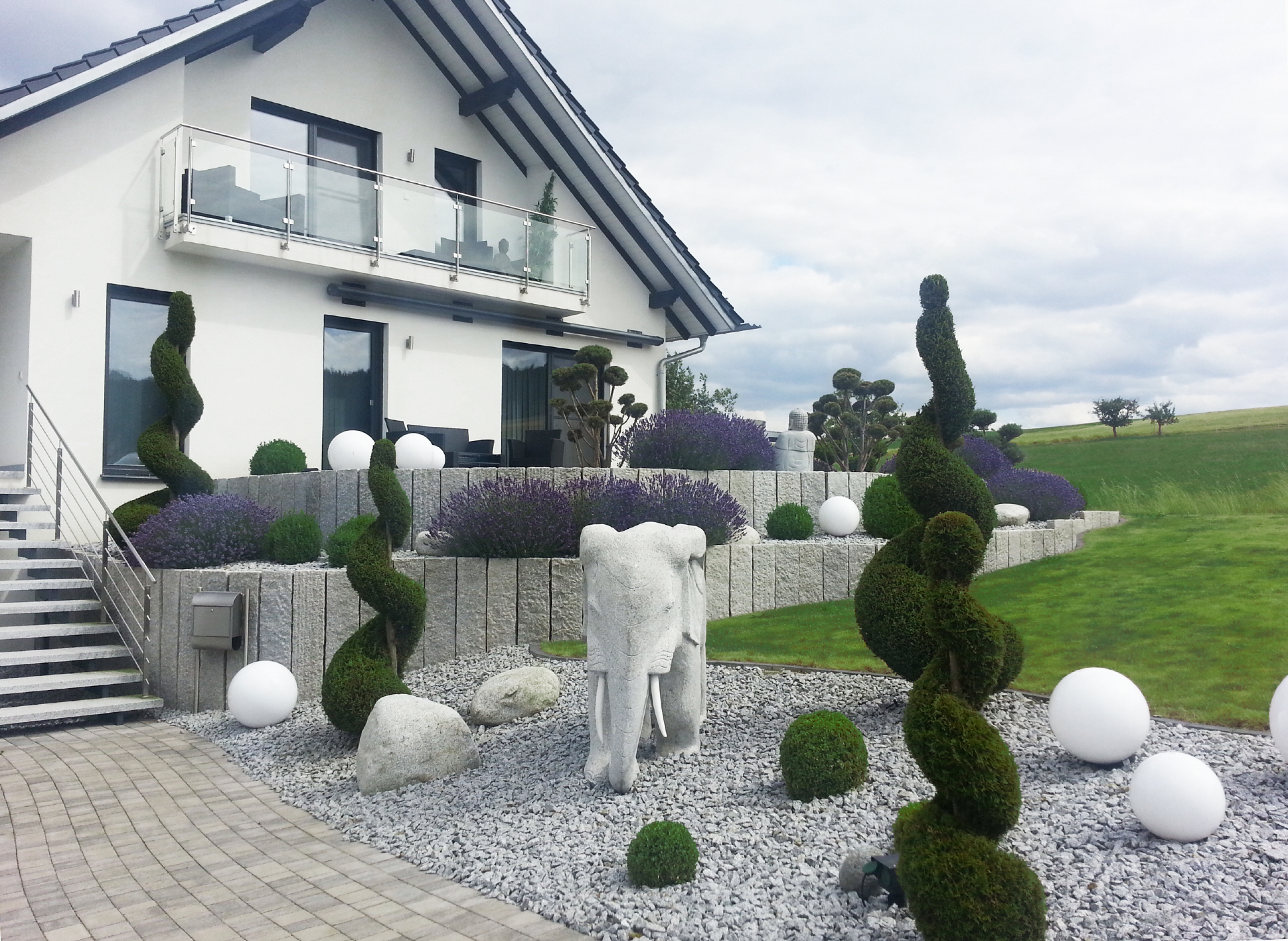 Moderner Garten mit Steinfiguren und Formschnitt